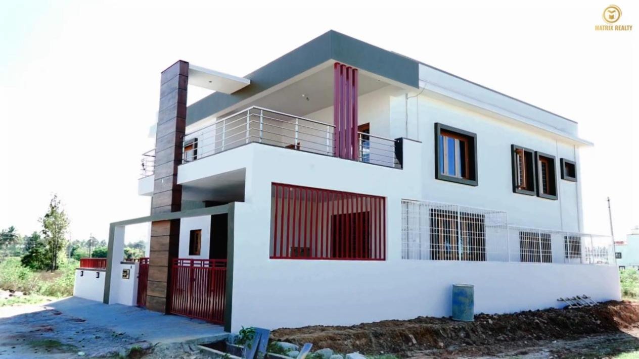 Corner view of the Hassan 4BHK duplex with balconies and compound wall
