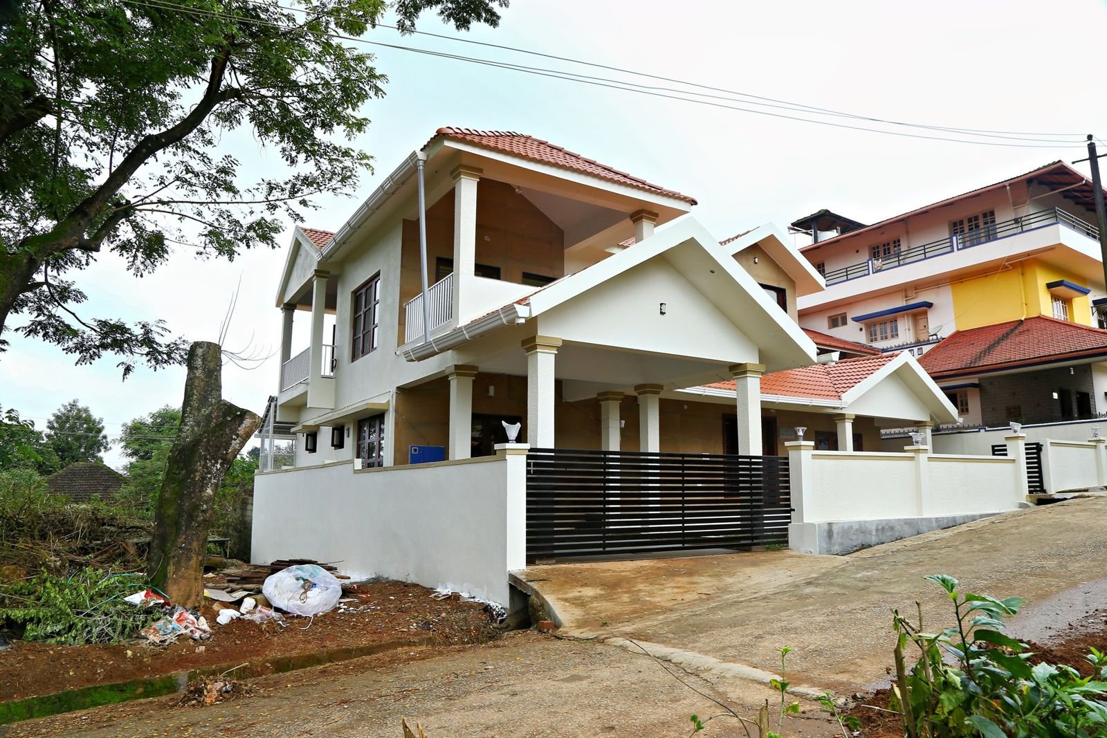Two-storey tiled-roof duplex house with balconies built by Matrix Realty in Sakleshpura