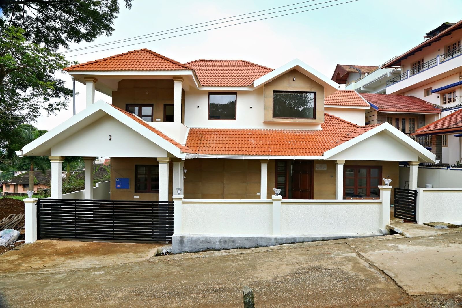 Two-storey tiled-roof house with portico and compound wall completed by Matrix Realty