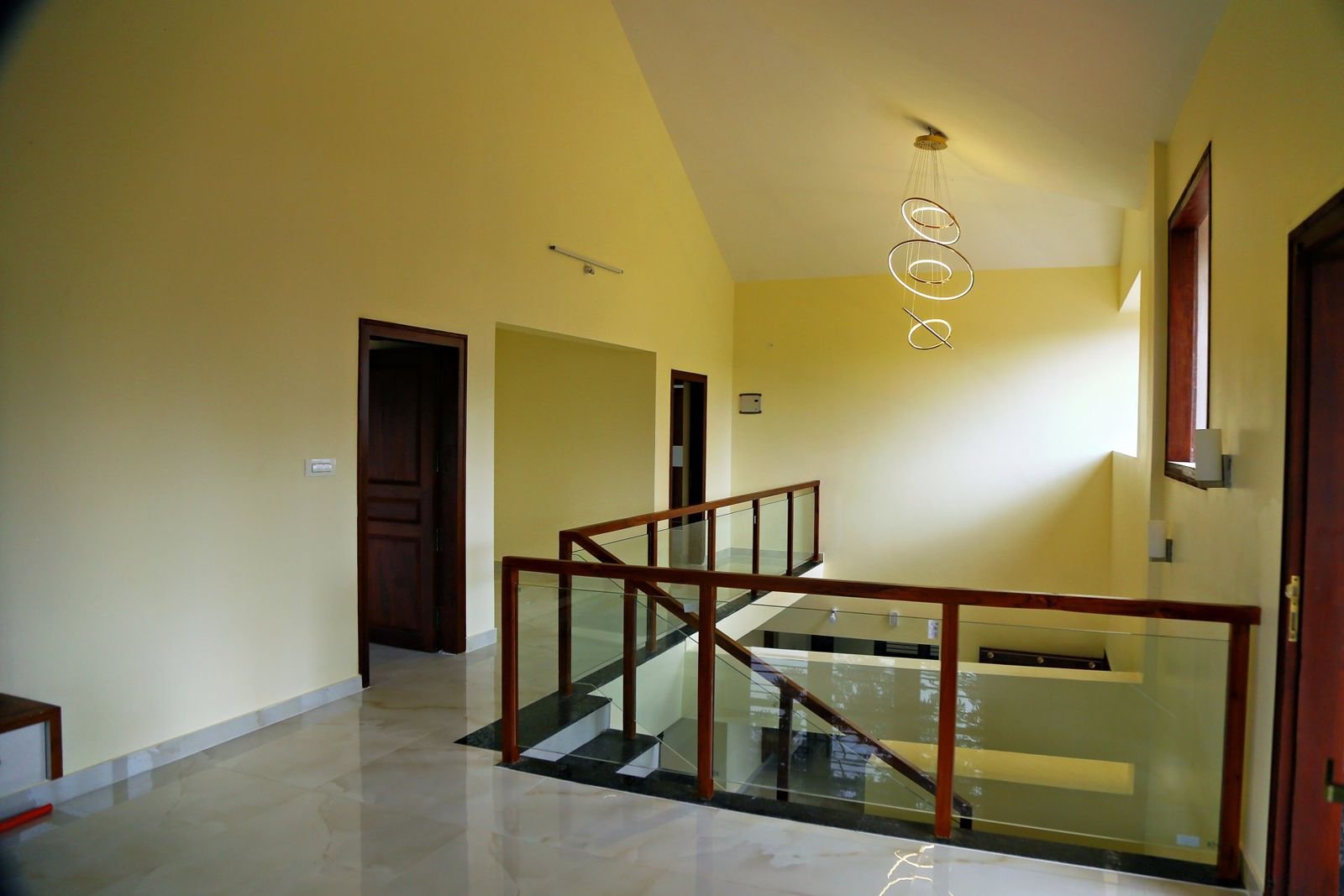 Upper-floor lounge with glass and teak staircase railing