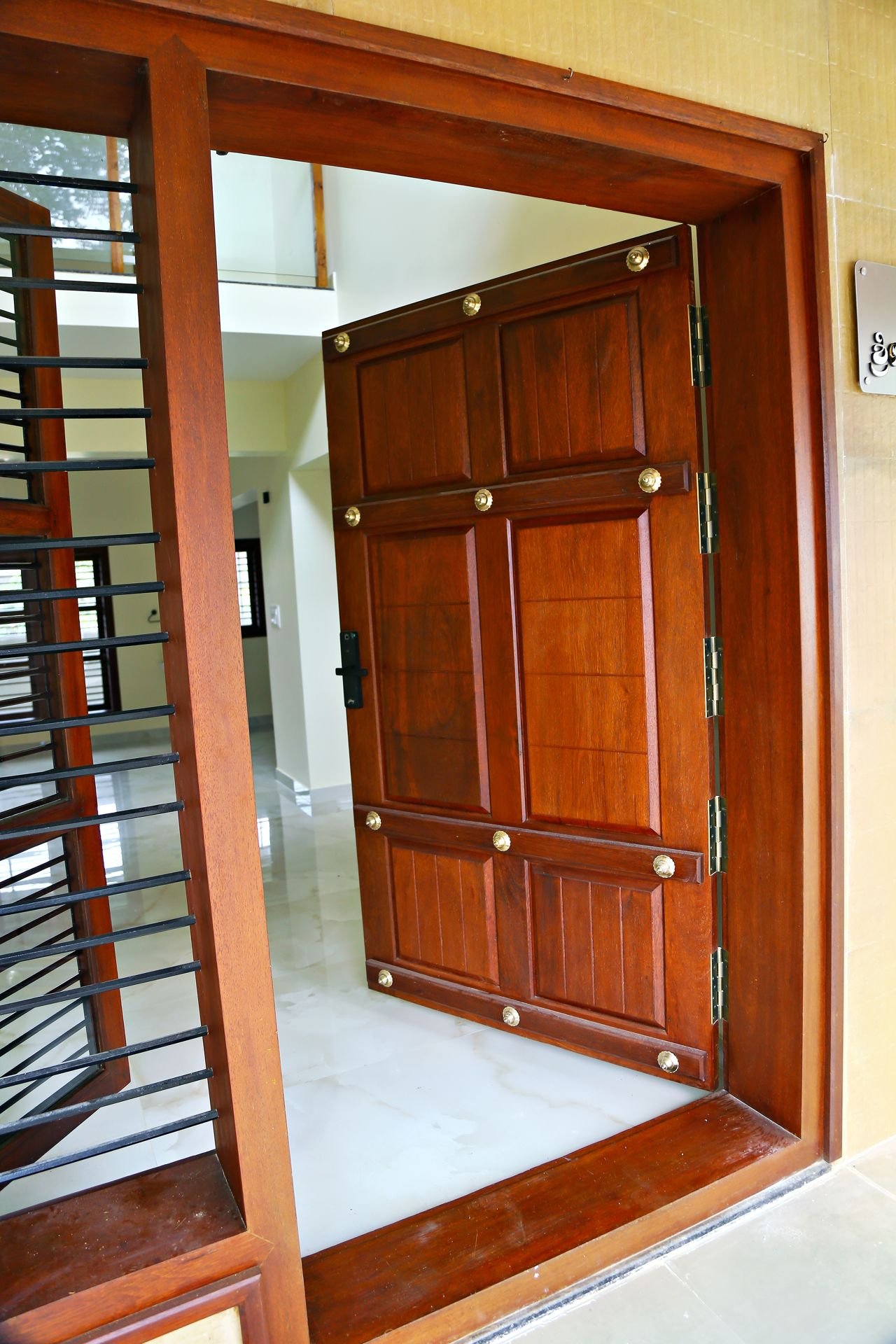 Traditional teak wood main entrance door with brass studs and teak window