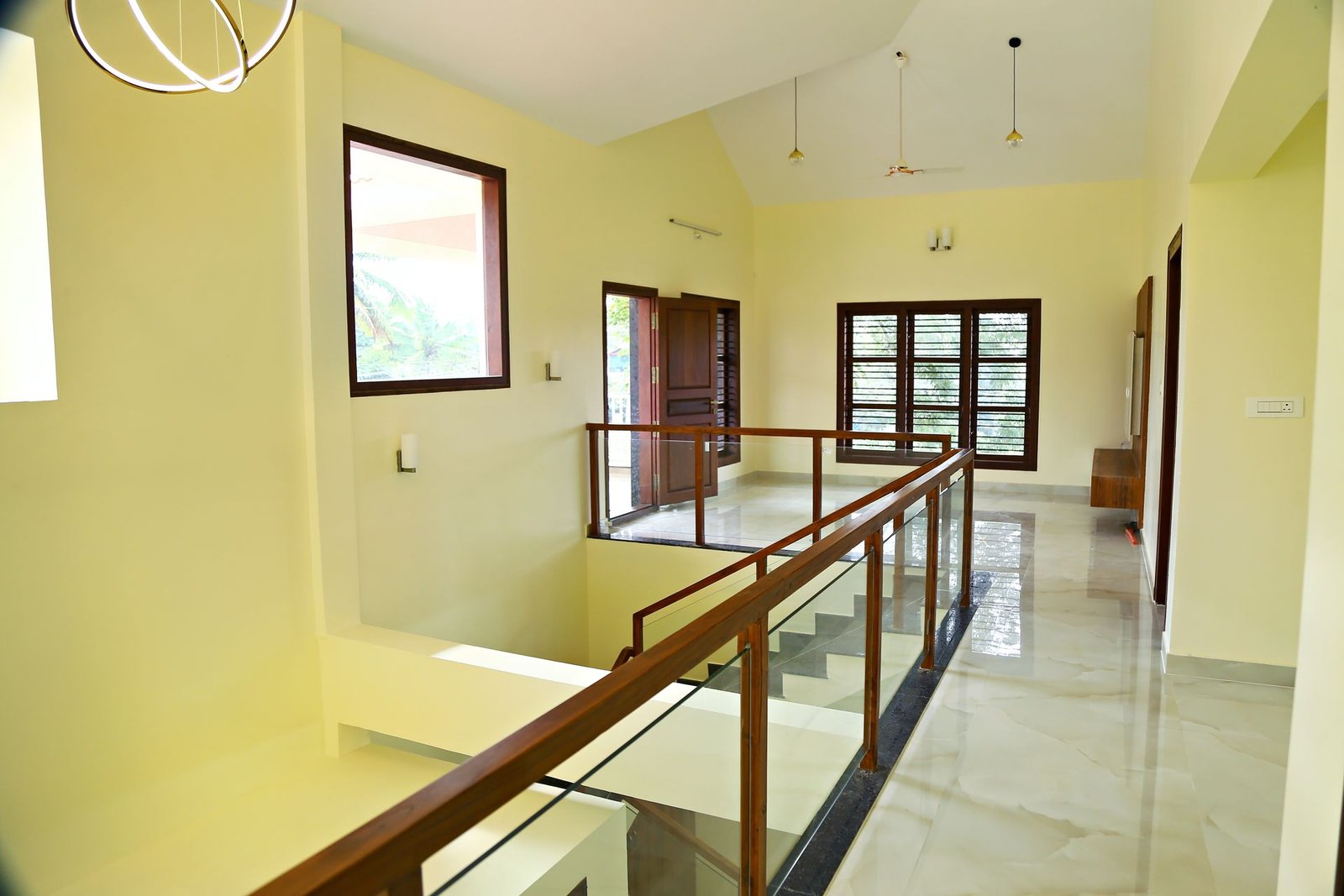 Upper-floor lounge with glass and teak staircase railing